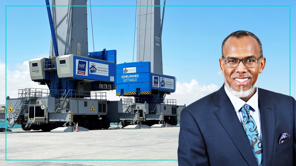 Two mobile harbour cranes at the Port of Mogadishu alongside a portrait of Ambassador Mohamed Ali Nur, Director General of the Mogadishu Port Authority.